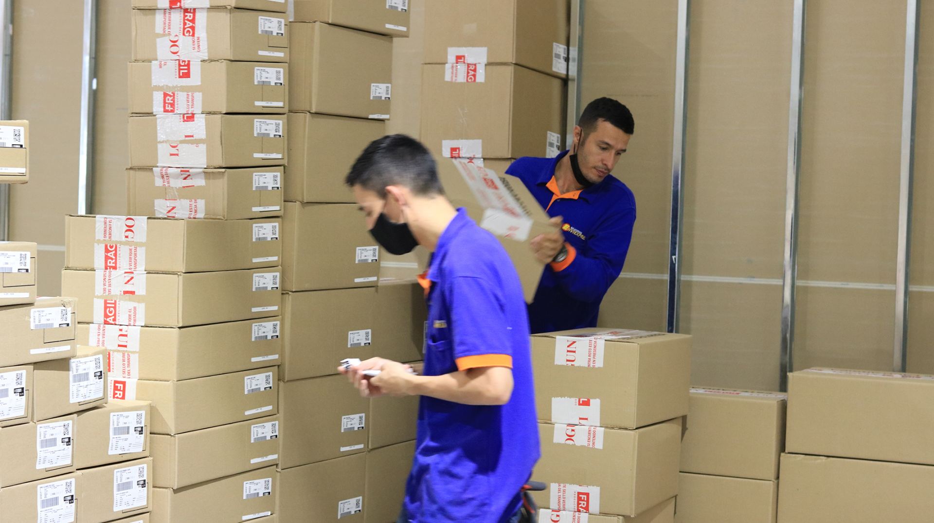 Operarios de EnviExpress preparando cajas para entregas de última milla